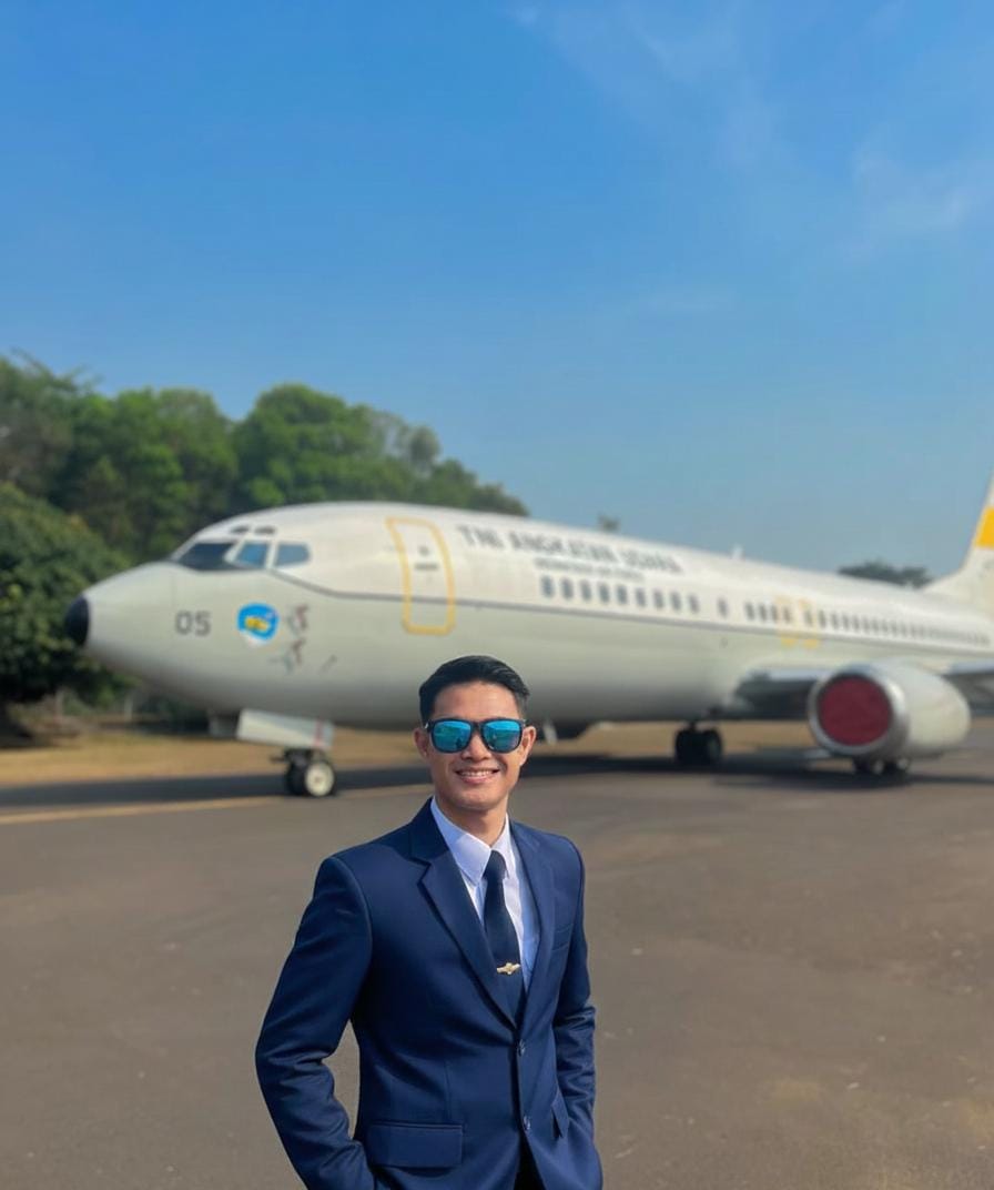 Indonesian man in navy blue suit with confident smile in modern office setting